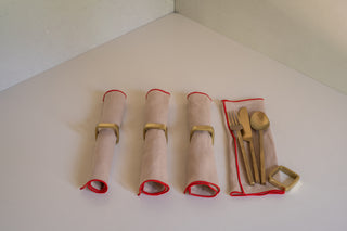 Lodhi Square Napkin Ring Set Around Madre Linen Milia Napkins in Crimini with One Napkin Open with Lodhi Flatware